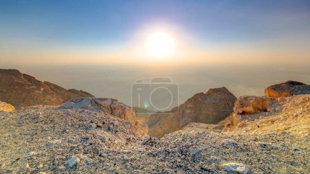 Photo for Sunset with rocks timelapse from Jebel Hafeet, mountain located primarily in the environs of Al Ain and offers an impressive view over the city. Aerial view from top - Royalty Free Image