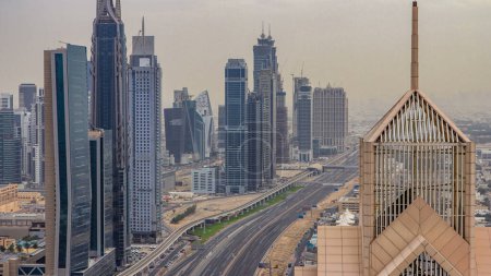 Téléchargez les photos : Temps d'horizon du centre-ville de Dubaï au coucher du soleil avec des gratte-ciel du centre-ville et le trafic routier Cheikh Zayed. Vue aérienne depuis le toit de la tour. Nuages sur le ciel. Dubai, Émirats arabes unis - en image libre de droit