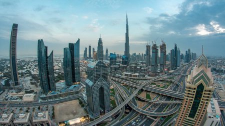 Téléchargez les photos : Des gratte-ciel modernes et des autoroutes animées le soir dans le centre-ville de Dubaï. Vue aérienne depuis le toit de la tour. Circulation routière. lentille Fisheye. Dubai, Émirats arabes unis - en image libre de droit
