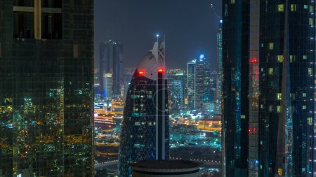 Foto de Rascacielos de dubai durante la noche timelapse. Vista cercana entre dos torres iluminadas al centro de Dubái desde la carretera Sheikh zayed. Vista superior aérea - Imagen libre de derechos