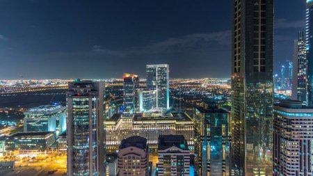 Téléchargez les photos : Dubaï ville architecture nuit timelapse. Vue aérienne sur la route Sheikh Zayed avec des gratte-ciel éclairés dans le quartier financier et la circulation. Hautes tours et ciel nuageux - en image libre de droit