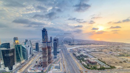 Business bay towers with sunset aerial. Rooftop view of some skyscrapers and new towers under construction. Dubai water canal with bridges and Sheikh Zayed road traffic. Cloudy colorful evening sky Stickers 710556628