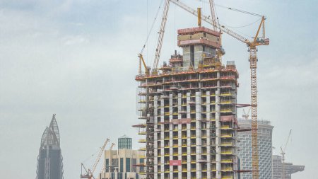 Téléchargez les photos : Site de construction à Dubaï timelapse, Émirats arabes unis. Grues jaunes et les travailleurs sur la construction. Vue aérienne du dessus - en image libre de droit