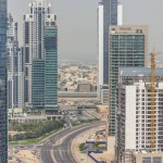 Dubai business bay towers at day time aerial timelapse. Rooftop view of some skyscrapers and new towers under construction. Traffic on the road