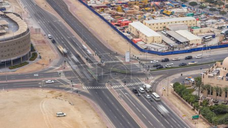 Foto de Vista superior del tráfico de la ciudad en una encrucijada en Dubai Centro timelapse. Vista aérea superior del cruce de carreteras desde arriba, tráfico de automóviles y atasco de muchos coches, concepto de transporte - Imagen libre de derechos