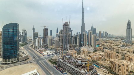 Photo for Beautiful luxury Dubai downtown aerial top panoramic view timelapse, Dubai, United Arab Emirates. Rooftop view from business bay towers with clouds on sky. Traffic on the road - Royalty Free Image