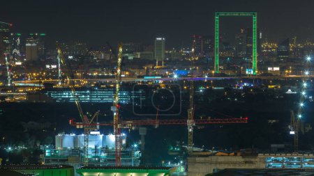 Photo for Dubai skyline night timelapse with illuminated landmarks. Aerial top view from Dubai downtown to Deira district - Royalty Free Image