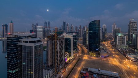 Foto de Dubai Centro de la ciudad y la bahía de negocios noche a día timelapse transición. Vista aérea de la gran ciudad futurista. Rascacielos de Dubai, Emiratos Árabes Unidos. skyline de la mañana desde la azotea - Imagen libre de derechos