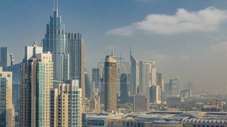 Photo for Downtown Dubai skyline with skyscrapers and towers timelapse, view from rooftop. Clouds on the sky - Royalty Free Image