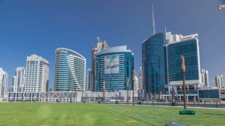 Photo for Panoramic timelapse view of business bay and downtown area of Dubai. Modern skyscrapers, green grass and blue sky - Royalty Free Image