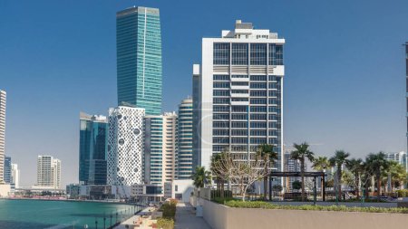 Panoramic timelapse view of business bay and downtown area of Dubai. Modern skyscrapers reflected in water and blue sky. Top view from bridge with trees puzzle 710558020