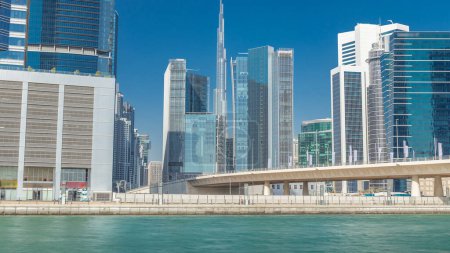 Panoramic timelapse view of business bay and downtown area of Dubai. Modern skyscrapers reflected in water and blue sky. View near bridge puzzle 710558086