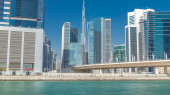 Panoramic timelapse view of business bay and downtown area of Dubai. Modern skyscrapers reflected in water and blue sky. View near bridge Sweatshirt #710558086