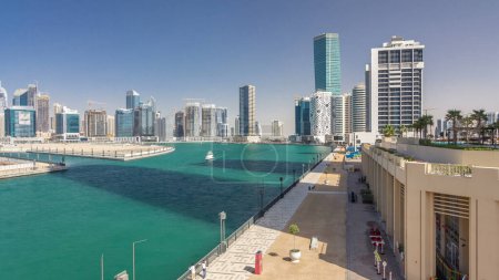 Panoramic timelapse hyperlapse view of business bay and downtown area of Dubai. Modern skyscrapers reflected in water and blue sky. Top view from bridge