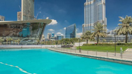 Photo for Park with fountain pool timelapse hyperlapse. Dubai Opera and modern skyscrapers on background in Downtown, Dubai, United Arab Emirates - Royalty Free Image