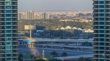 Téléchargez les photos : Dubai Marina skyscrapers aerial timelapse, Dubai, Émirats arabes unis. Les ombres bougent au coucher du soleil. Circulation sur la route entre deux tours - en image libre de droit