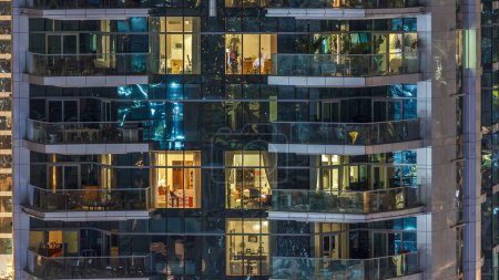 Téléchargez les photos : Fenêtres éclatantes scéniques de gratte-ciel au timelapse du soir. Vue des immeubles résidentiels modernes de la marina de Dubaï. Des gens qui déménagent dans des appartements. Vue aérienne du dessus
. - en image libre de droit