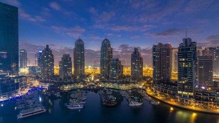 Photo for Aerial panoramic view of modern skyscrapers night to day transition timelapse before sunrise in Dubai Marina with yachts in Dubai, UAE. Illuminated towers early morning - Royalty Free Image