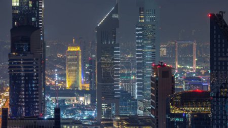 Geschäftsviertel im Zeitraffer der Sommernacht. Moderne beleuchtete Wolkenkratzer in der Luftaufnahme des Finanzzentrums. Dubai, VAE.