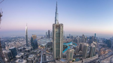Téléchargez les photos : Dubai Downtown day to night transition timelapse modern towers panorama from the top in Dubai, Émirats arabes unis. Circulation sur la route et fontaine à musique - en image libre de droit