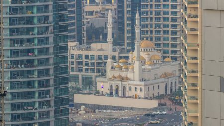 Téléchargez les photos : Mosquée Al Raheem entre les gratte-ciel timelapse sur la promenade de la marina à Dubai Marina, Dubaï, Émirats arabes unis. Vue aérienne du dessus tôt le matin au lever du soleil avec des ombres mouvantes - en image libre de droit