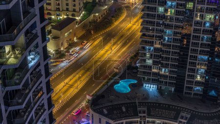 Téléchargez les photos : Illumination nocturne de Dubai Marina et JBR aerial timelapse, EAU. gratte-ciel et bâtiments résidentiels modernes. Trafic sur la route et fenêtres éclatantes - en image libre de droit