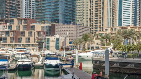 Téléchargez les photos : Vue avec des gratte-ciel modernes et jetée d'eau avec des yachts de Dubai Marina timelapse, vue depuis le front de mer au soleil. Émirats arabes unis - en image libre de droit