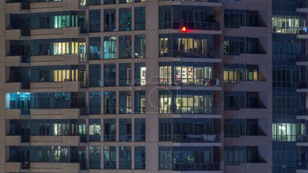 Téléchargez les photos : Fenêtres éclatantes de gratte-ciel à timelapse du soir. Vue des immeubles résidentiels et de bureaux modernes de la marina de Dubaï. Des gens qui entrent. Vue aérienne du dessus
. - en image libre de droit