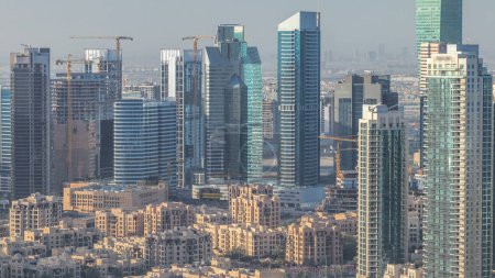 Photo for Dubai downtown morning scene timelapse with modern skyscrapers and old style buildings after sunrise. Top view from above - Royalty Free Image