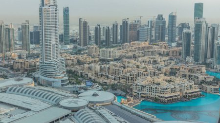 Téléchargez les photos : Dubaï centre-ville de jour à la nuit transition timelapse avec des gratte-ciel éclairés modernes, centre commercial et la circulation sur la route. Vue du dessus après le coucher du soleil - en image libre de droit