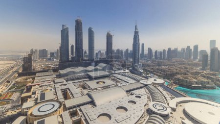 Photo for Dubai downtown during all day timelapse with modern skyscrapers, mall and traffic on the road. Top panoramic view from above. Shadows moving very fast - Royalty Free Image