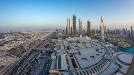 Foto de Dubai céntrico día a noche timelapse transición con modernos rascacielos iluminados, centro comercial y el tráfico en la carretera. Vista panorámica superior desde arriba después del atardecer - Imagen libre de derechos