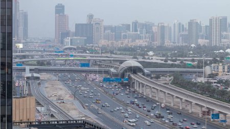 Téléchargez les photos : Vue aérienne des lacs Jumeirah tours gratte-ciel et quartier Al Barsha timelapse transition de jour à la nuit. Trafic sur Sheikh zayed route près du terrain de golf et de la ligne de métro. - en image libre de droit