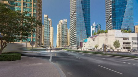 Dubai Marina with Skyscrapers timelapse hyperlapse and traffic on intersection on concrete road bridge through the canal. Sunny day with blue sky. Dubai, United Arab Emirates.