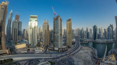 Téléchargez les photos : Vue panoramique aérienne de la promenade et du canal de Dubai Marina avec des yachts flottants et des bateaux après le coucher du soleil à Dubaï, Émirats Arabes Unis. Tours et circulation modernes - en image libre de droit