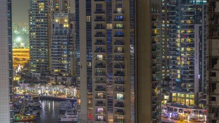 Téléchargez les photos : Canal d'eau et promenade sur Dubai Marina skyline la nuit timelapse. Tours résidentielles avec éclairage et éclairage. Yachts flottants et bateaux avec trafic près des gratte-ciel - en image libre de droit