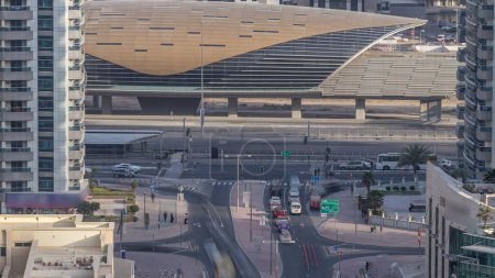 Foto de Dubai Marina intersección durante la puesta del sol timelapse. Gran perspectiva de rascacielos y estación de metro con tráfico. Luz solar sobre los edificios. Emiratos Árabes Unidos. - Imagen libre de derechos