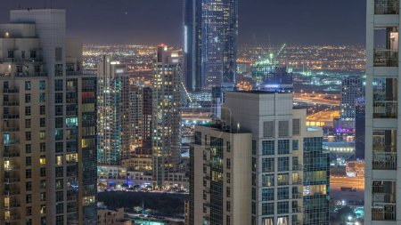Photo for Dubai downtown and business bay night timelapse, illuminated luxury modern buildings, futuristic cityscape of United Arab Emirates. Aerial top view from skyscraper - Royalty Free Image