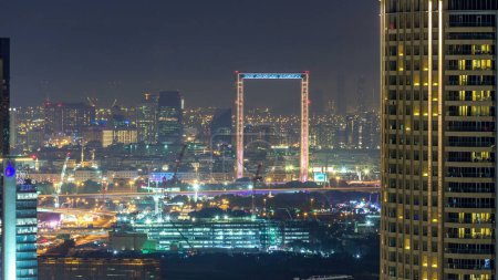 Photo for Dubai skyline night timelapse with Deira district. Aerial top view from Dubai downtown at evening with illuminated skyscrapers - Royalty Free Image
