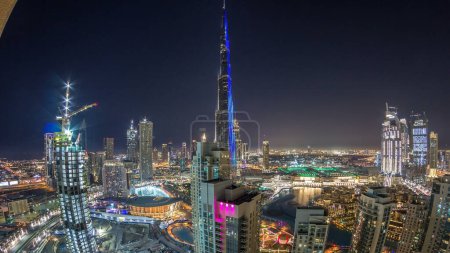 Photo for Dubai downtown skyline cityscape with Burj Khalifa, LightUp light show aerial timelapse from rooftop. With the largest light and sound show on a single building - Royalty Free Image