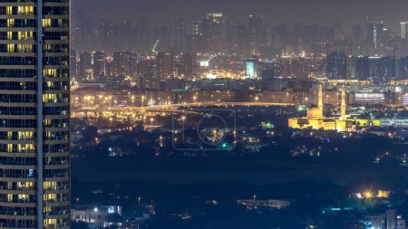 Foto de Skyline of Deira and Sharjah districts in Dubai at night, UAE (en inglés). Vista aérea desde la azotea del centro. Deira distrito históricamente ha sido el centro comercial de Dubai y se erige como un importante puerto - Imagen libre de derechos