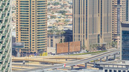 Téléchargez les photos : Trafic sur une intersection achalandée sur l'autoroute Cheikh Zayed timelapse aérien. Vue depuis le toit du gratte-ciel à une journée ensoleillée - en image libre de droit