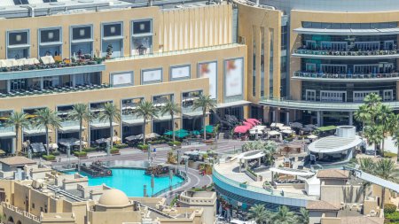 Foto de Balcón de centro comercial con gente mirando a la piscina de fuentes timelapse en Dubai, Emiratos Árabes Unidos. Vista aérea desde el rascacielos - Imagen libre de derechos