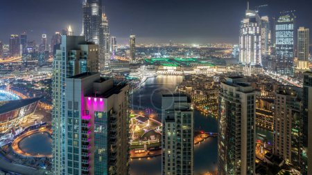 Photo for Dubai downtown night timelapse, illuminated luxury modern buildings and fountain, futuristic cityscape of United Arab Emirates. Aerial top view from skyscraper - Royalty Free Image