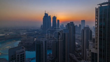 Téléchargez les photos : Lever de soleil matinal dans le centre de Dubaï et timelapse de la baie d'affaires. Vue futuriste des gratte-ciel de la ville couverts de brouillard. Vue aérienne depuis le toit avec des tours modernes. Dubai, Émirats arabes unis - en image libre de droit
