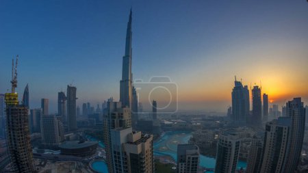 Téléchargez les photos : Foggy matin lever du soleil panorama dans le centre de Dubaï timelapse. Vue futuriste des gratte-ciel de la ville couverts de brouillard. Vue aérienne depuis le toit avec des tours modernes. Dubai, Émirats arabes unis - en image libre de droit