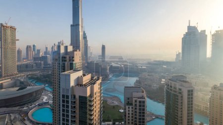 Foto de Mañana brumosa en el centro de Dubai timelapse. Vista panorámica futurista de los rascacielos de la ciudad cubiertos de niebla. Vista aérea desde la azotea con torres modernas durante el amanecer. Dubai, Emiratos Árabes Unidos - Imagen libre de derechos
