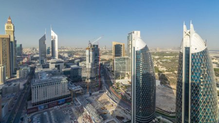 Foto de Vista panorámica de los edificios de Sheikh Zayed Road y DIFC timelapse en Dubai, Emiratos Árabes Unidos. Rascacielos en vista aérea del centro financiero desde arriba antes del atardecer - Imagen libre de derechos