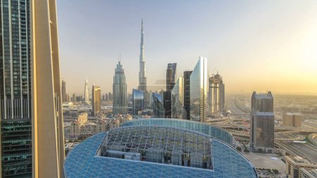 Téléchargez les photos : Dubaï skyline panoramique au coucher du soleil timelapse avec le plus haut bâtiment et Sheikh Zayed circulation routière, EAU. Vue aérienne depuis le toit du gratte-ciel avec des tours modernes - en image libre de droit