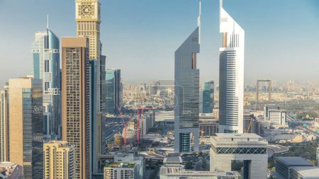 Foto de Vista panorámica de los edificios de Sheikh Zayed Road y DIFC timelapse en Dubai, Emiratos Árabes Unidos. Rascacielos y torres gemelas en vista aérea del centro financiero desde arriba antes del atardecer - Imagen libre de derechos